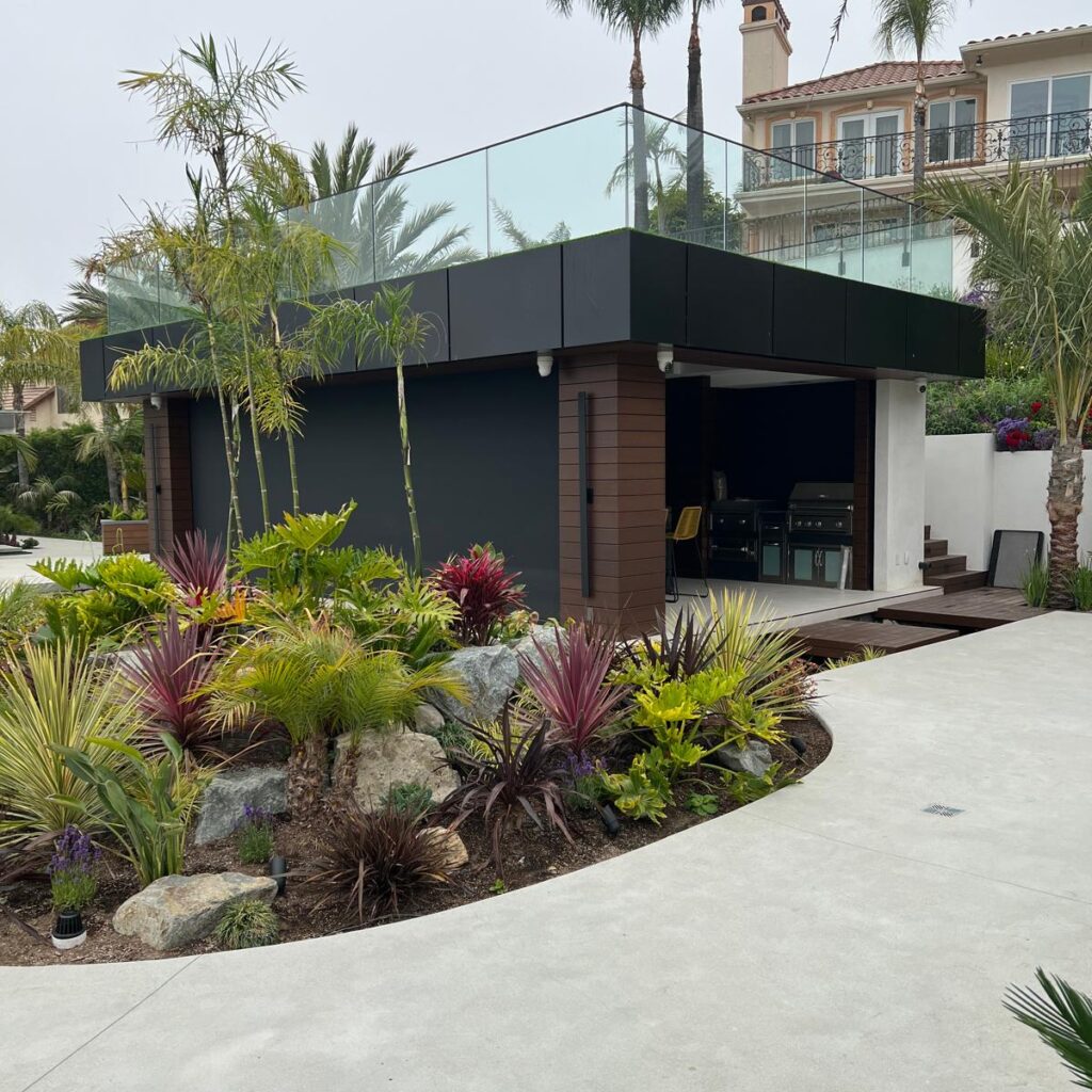 ACP canopy with black aluminum composite panels and glass railing over an outdoor kitchen in Los Angeles